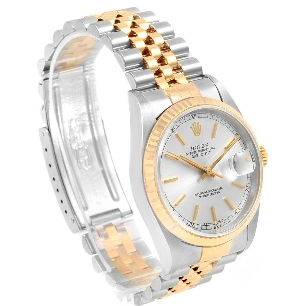 The Rolex Datejust 16233 Men's Steel and Gold (two tone) Silver Dial 16233 Men's Steel and Gold (two tone) Silver Dial watch is shown from a three-quarter angle, highlighting its bezel, dial, and partially extended bracelet.