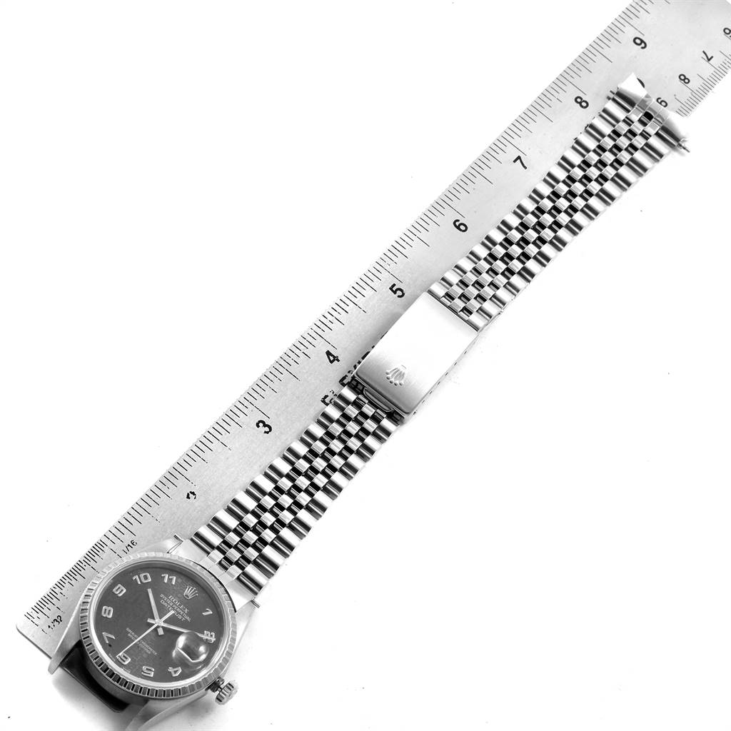 The image shows a top-down view of a Rolex Datejust 16220 Men's Stainless Steel Grey Dial 16220 Men's Stainless Steel Grey Dial watch, displaying the face, band, and clasp, alongside a ruler for scale.
