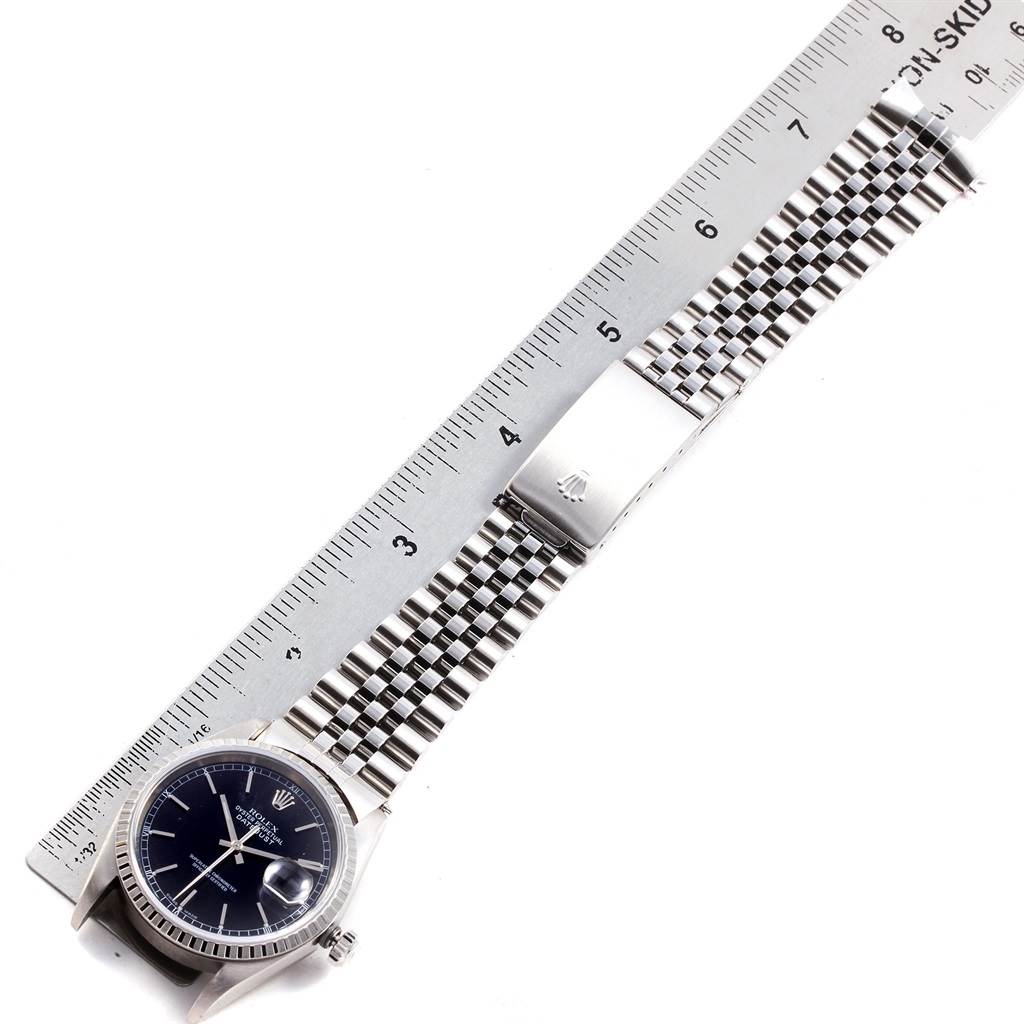 The Rolex Datejust 16220 Men
s Stainless Steel Black Dial 16220 Men
s Stainless Steel Black Dial watch is shown from a top-down angle, with focus on the face and band, alongside a measuring ruler.