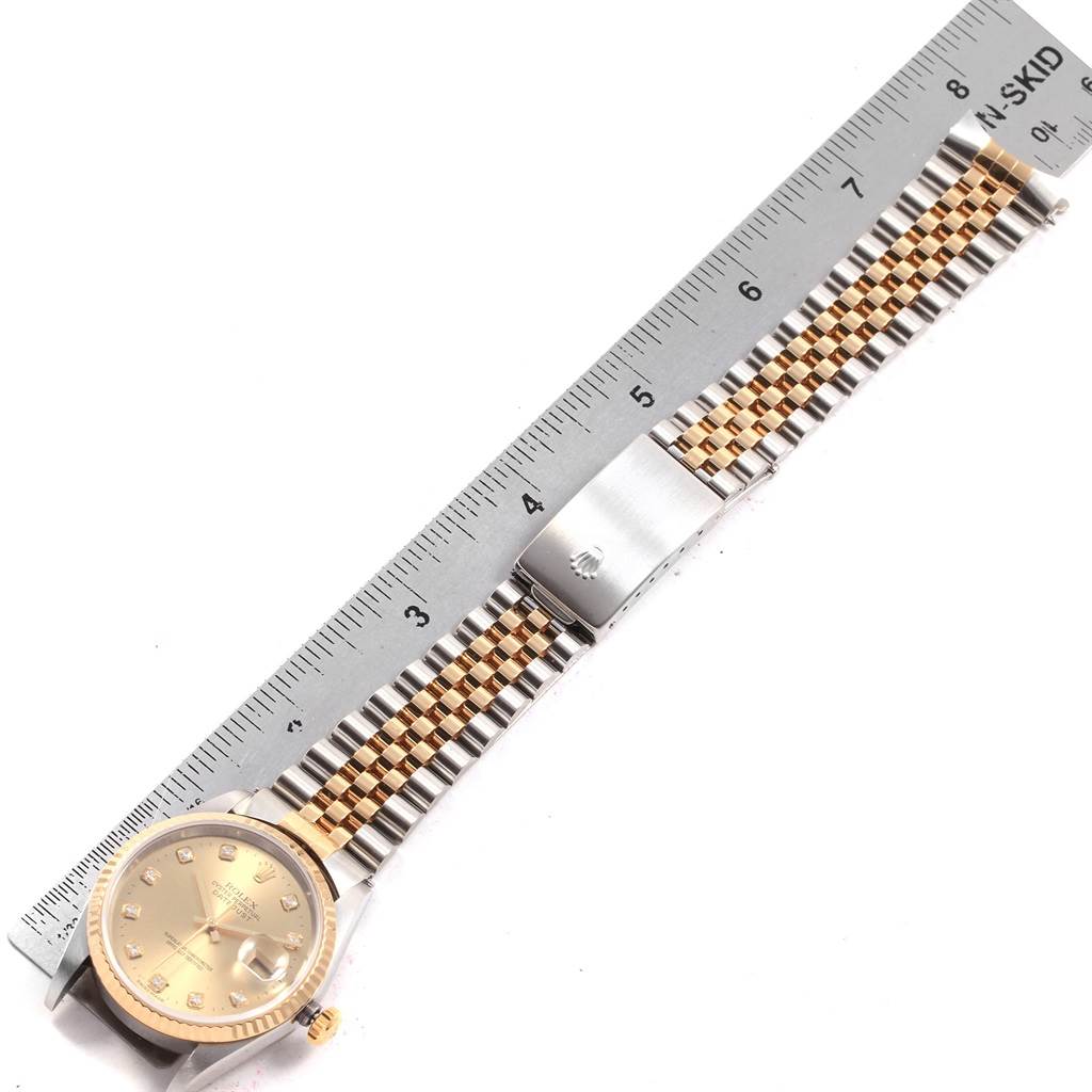 This image shows a Rolex Datejust 16233 Men's Steel and Gold (two tone) Champagne Dial 16233 Men's Steel and Gold (two tone) Champagne Dial watch laid flat with a Jubilee bracelet and a scale ruler beside it.