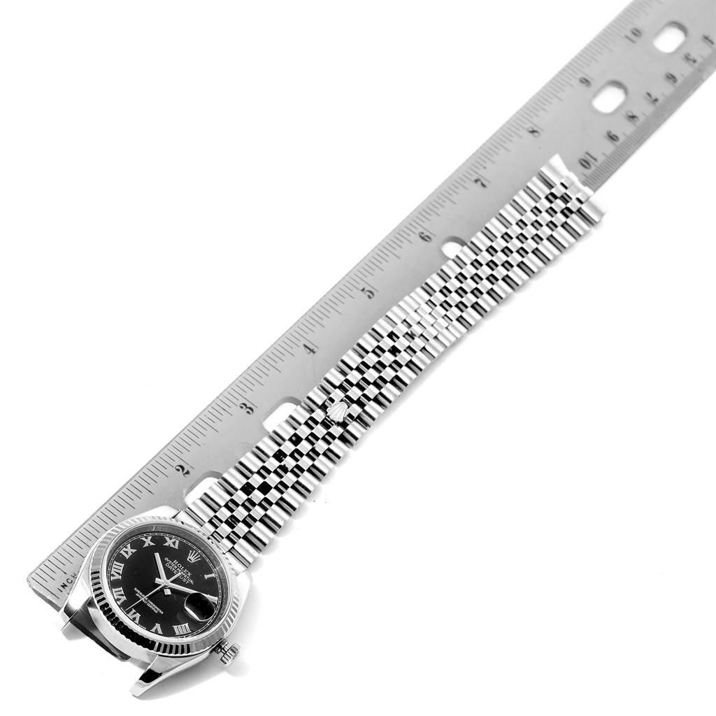 This image shows a Rolex Datejust 116234 Men's Stainless Steel Black Dial 116234 Men's Stainless Steel Black Dial watch's face and bracelet alongside a ruler, viewed from a top-down angle.