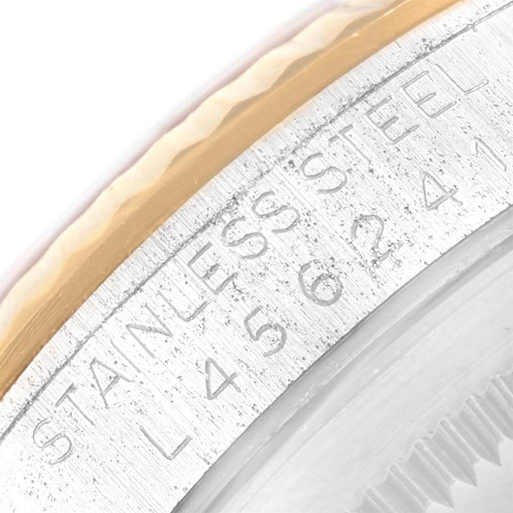 This close-up image shows the fluted bezel and part of the stainless steel case back of a Rolex Datejust 16233 Men's Steel and Gold (two tone) Silver Dial 16233 Men's Steel and Gold (two tone) Silver Dial watch.