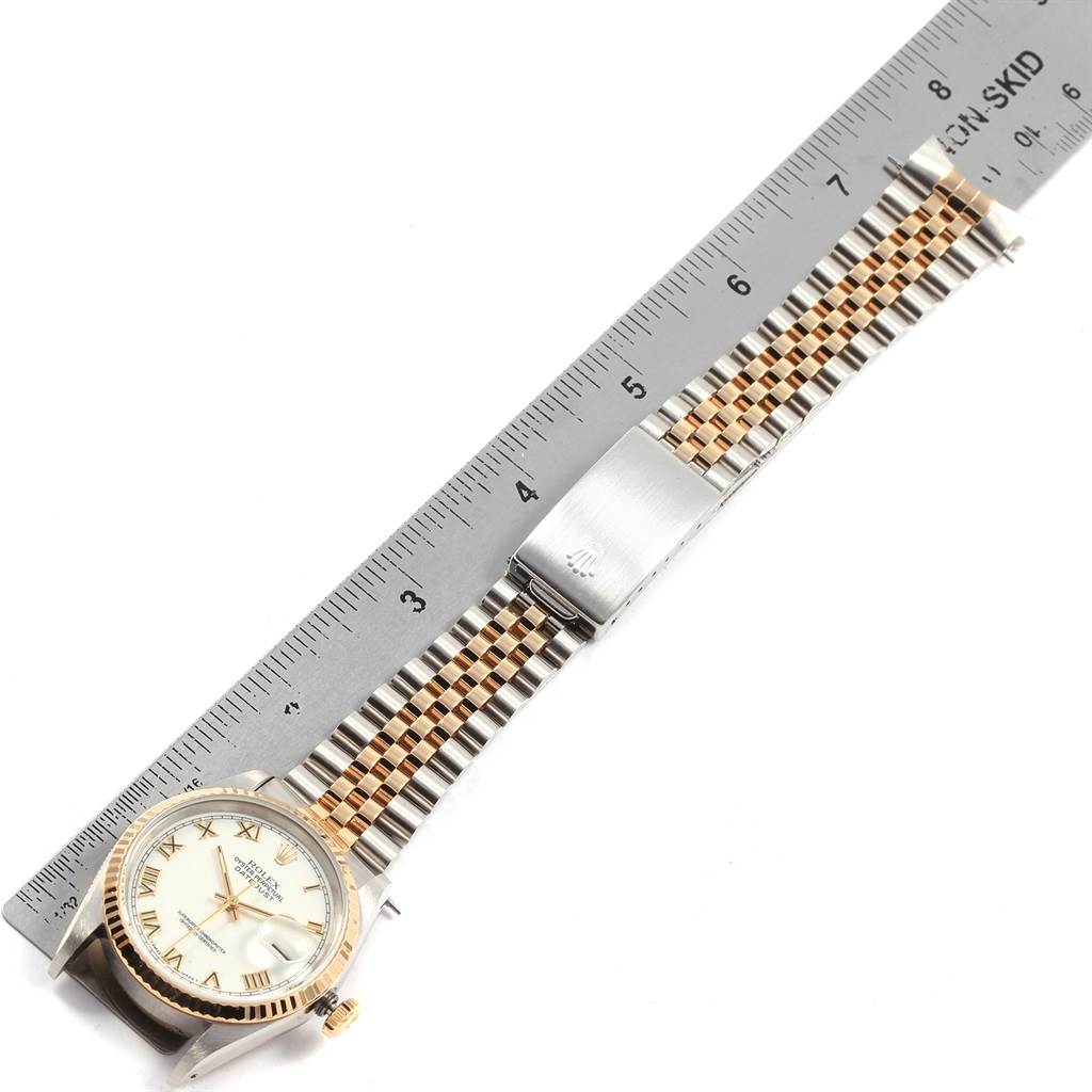 The image shows a top-down view of a Rolex Datejust 16233 Men's Steel and Gold (two tone) White Dial 16233 Men's Steel and Gold (two tone) White Dial watch with a two-tone metal bracelet placed next to a ruler.