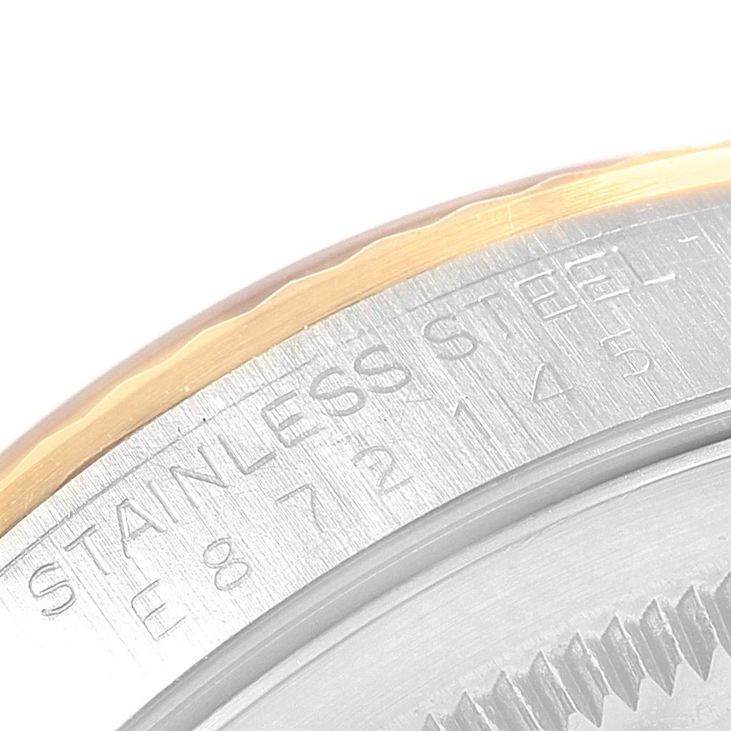 The image shows a close-up view of the case back edge of a Rolex Datejust 16233 Men's Steel and Gold (two tone) White Dial 16233 Men's Steel and Gold (two tone) White Dial, revealing part of the bezel and engraved text on the casing.