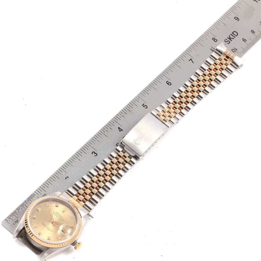 The image shows a Rolex Datejust 16233 Men's Steel and Gold (two tone) Champagne Dial 16233 Men's Steel and Gold (two tone) Champagne Dial watch laid flat with a metal ruler measuring its two-tone bracelet and clasp.
