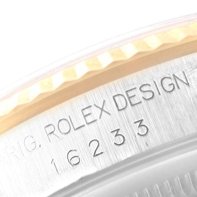 This close-up image of the Rolex Datejust 16233 Men's Steel and Gold (two tone) Champagne Dial 16233 Men's Steel and Gold (two tone) Champagne Dial watch model shows the engraved "ROLEX DESIGN" and model number on the case.