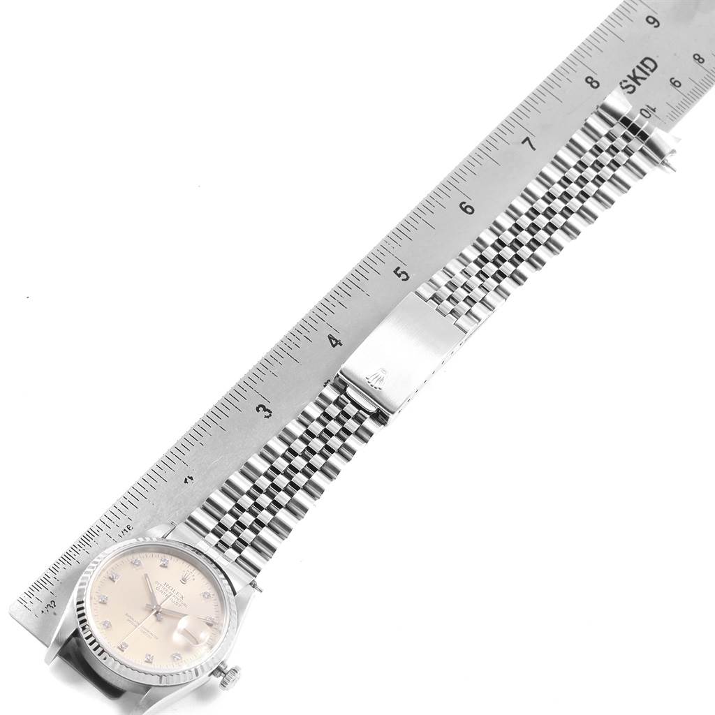 The image shows a Rolex Datejust 16234 Men
s Stainless Steel Silver Dial 16234 Men
s Stainless Steel Silver Dial watch and its metal bracelet, lying flat next to a ruler for measurement.