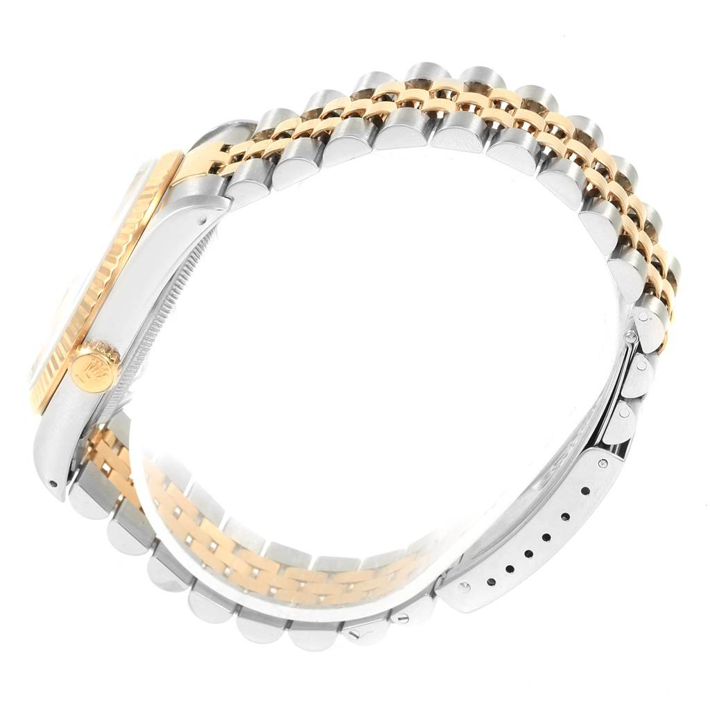 The image shows a side view of the Rolex Datejust 16233 Men
s Steel and Gold (two tone) Champagne Dial 16233 Men
s Steel and Gold (two tone) Champagne Dial watch, highlighting its two-tone bracelet and crown.