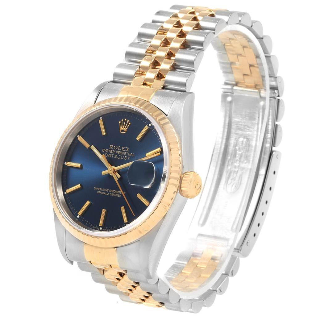 The image shows a Rolex Datejust 16233 Men's Steel and Gold (two tone) Blue Dial 16233 Men's Steel and Gold (two tone) Blue Dial watch at an angled side view, displaying its blue dial, two-tone bracelet, and fluted bezel.