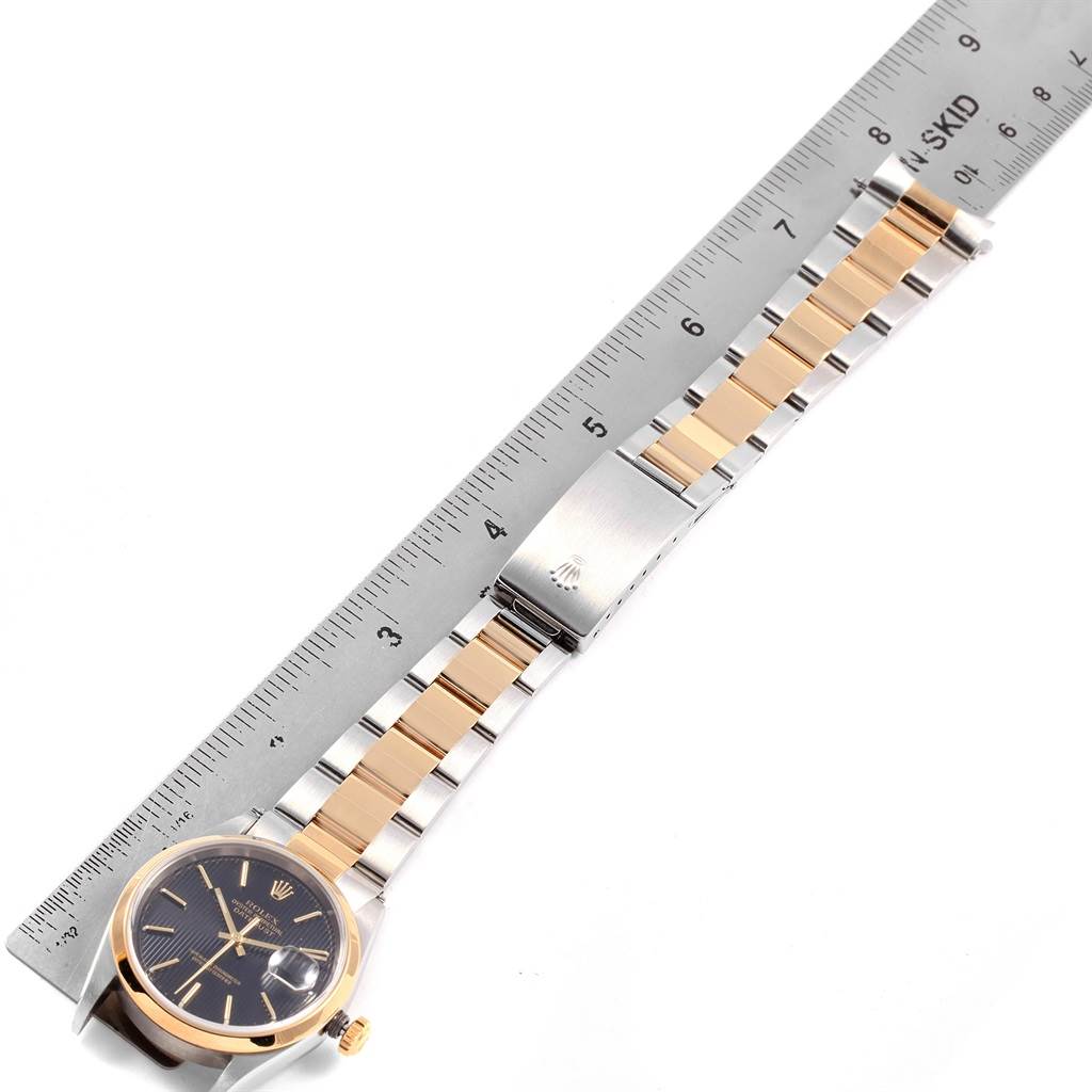 The Rolex Datejust 16203 Men's Steel and Gold (two tone) Black Dial 16203 Men's Steel and Gold (two tone) Black Dial watch is shown at a diagonal angle, displaying its dial, bracelet, and clasp.