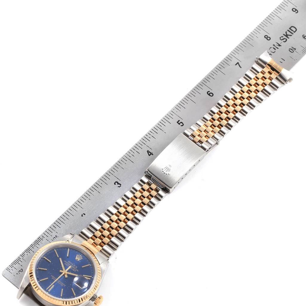 The image shows a Rolex Datejust 16233 Men's Steel and Gold (two tone) Blue Dial 16233 Men's Steel and Gold (two tone) Blue Dial watch laid flat with a ruler beside it, highlighting the length of the watch and bracelet.