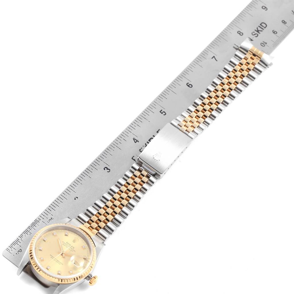 This image shows the front view of a Rolex Datejust 16233 Men's Steel and Gold (two tone) Champagne Dial 16233 Men's Steel and Gold (two tone) Champagne Dial watch, highlighting the gold and silver bracelet against a ruler.