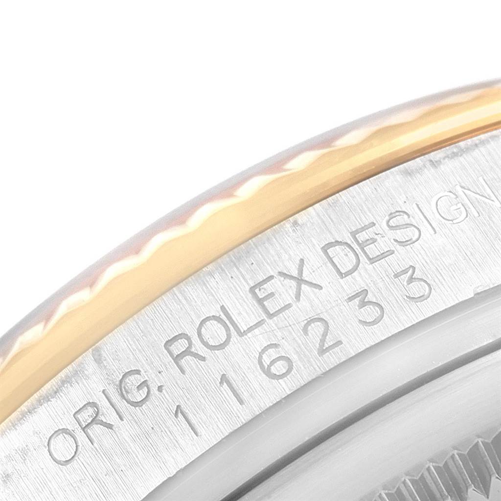The image shows a close-up of the side of a Rolex Datejust 116233 Men's Stainless Steel Blue Dial 116233 Men's Stainless Steel Blue Dial watch, highlighting the bezel and engraved serial number.