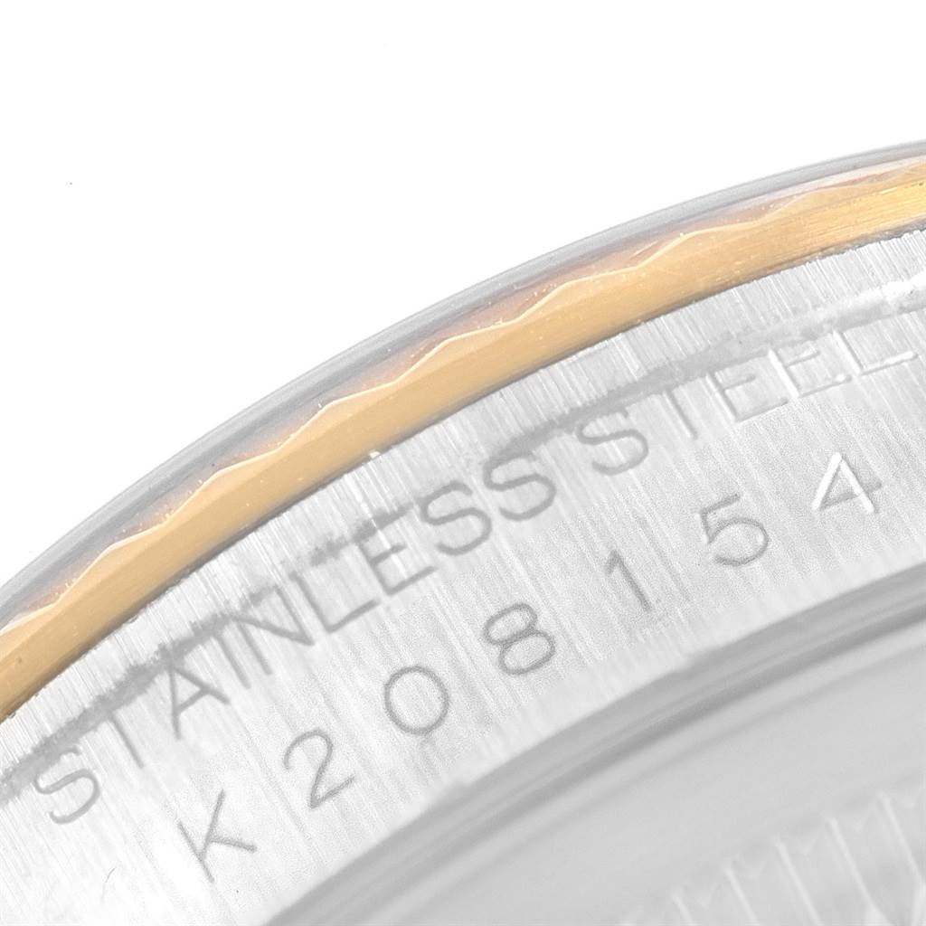 This close-up image shows the edge of the caseback and part of the rehaut of a Rolex Datejust 16233 Men's Steel and Gold (two tone) Black Dial 16233 Men's Steel and Gold (two tone) Black Dial watch, displaying the serial number and material.