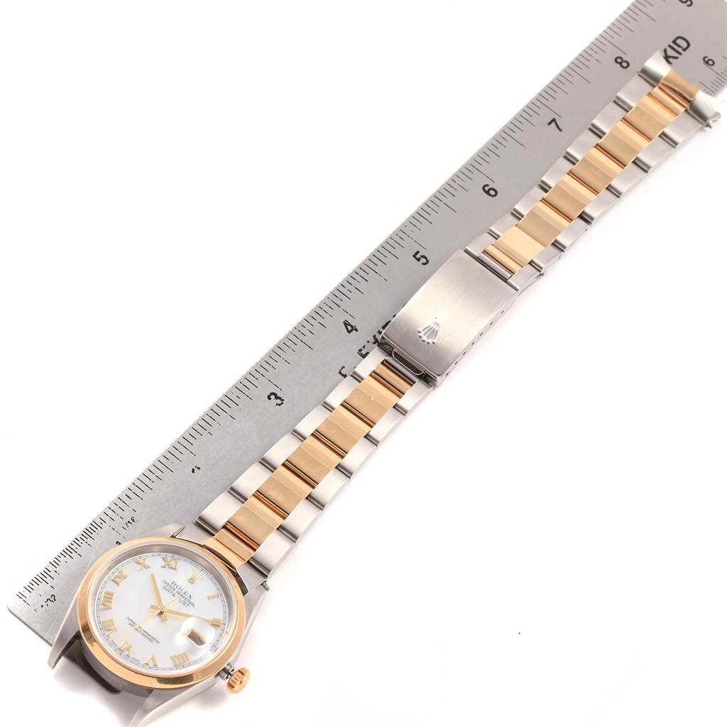 This image shows a Rolex Datejust 16203 Men's Steel and Gold (two tone) Mother of Pearl Dial 16203 Men's Steel and Gold (two tone) Mother of Pearl Dial watch lying flat, displaying the bracelet and clasp alongside a ruler for scale.