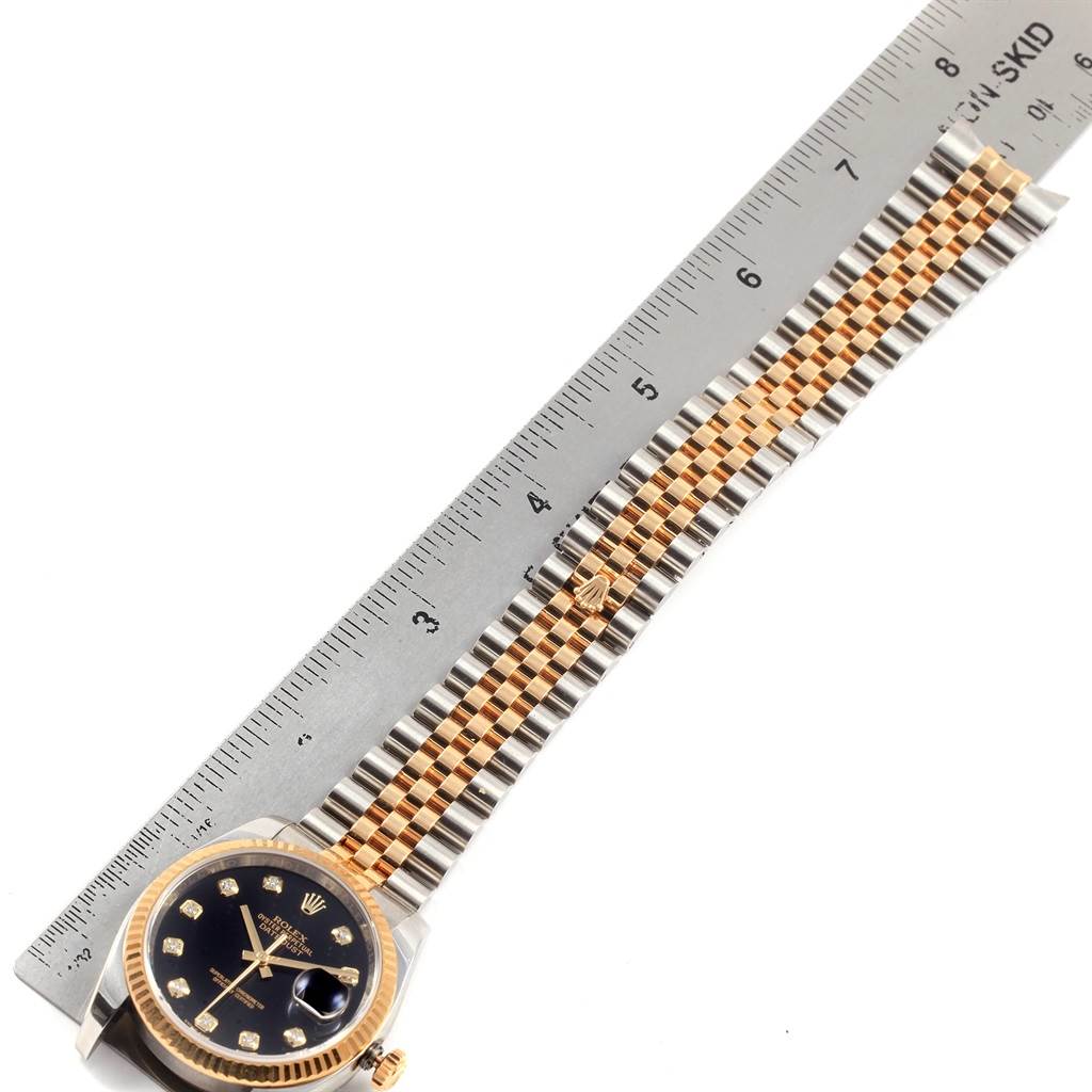 The image shows the face and bracelet of a Rolex Datejust 116233 Men
s Stainless Steel Black Dial 116233 Men
s Stainless Steel Black Dial model, positioned alongside a ruler for measurement.