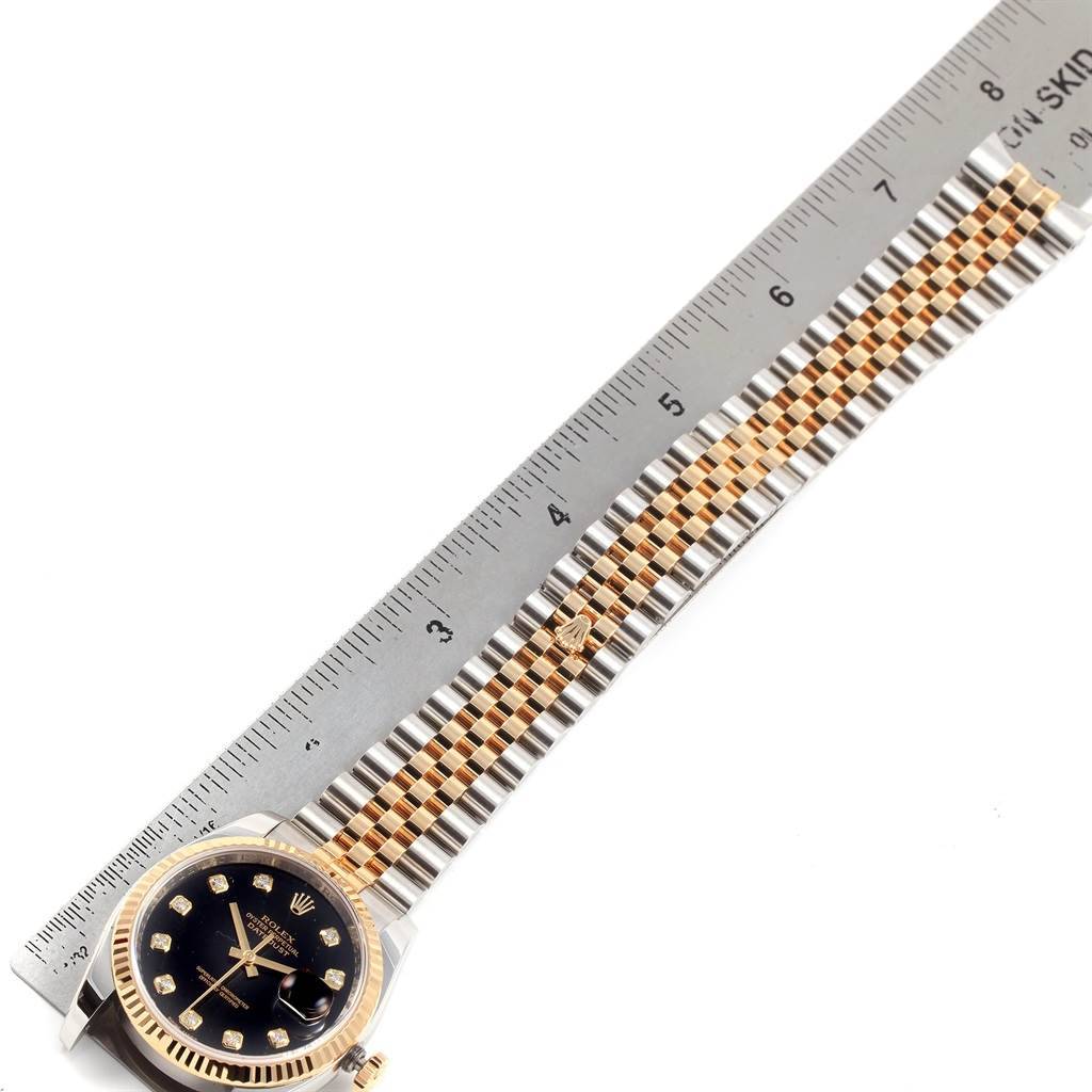 The image shows a Rolex Datejust 116233 Men's Stainless Steel Black Dial 116233 Men's Stainless Steel Black Dial watch with a ruler indicating its length, displaying the face and the full band.