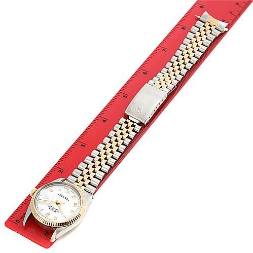 The Rolex Datejust 16013 Men's Stainless Steel White Dial 16013 Men's Stainless Steel White Dial watch is shown from a top view, highlighting its face, bezel, and bracelet along a measuring ruler.