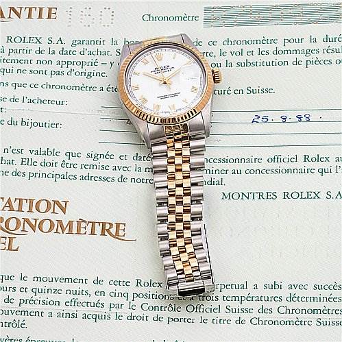 The image shows a Rolex Datejust 16013 Men's Stainless Steel White Dial 16013 Men's Stainless Steel White Dial watch lying flat on top of its certificate, with a clear view of the face, bracelet, and part of the crown.