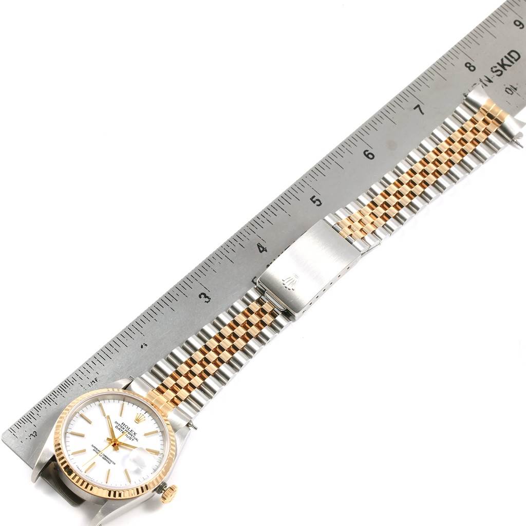 The image shows a top-down view of a Rolex Datejust 16233 Men's Steel and Gold (two tone) White Dial 16233 Men's Steel and Gold (two tone) White Dial watch with a ruler for scale.