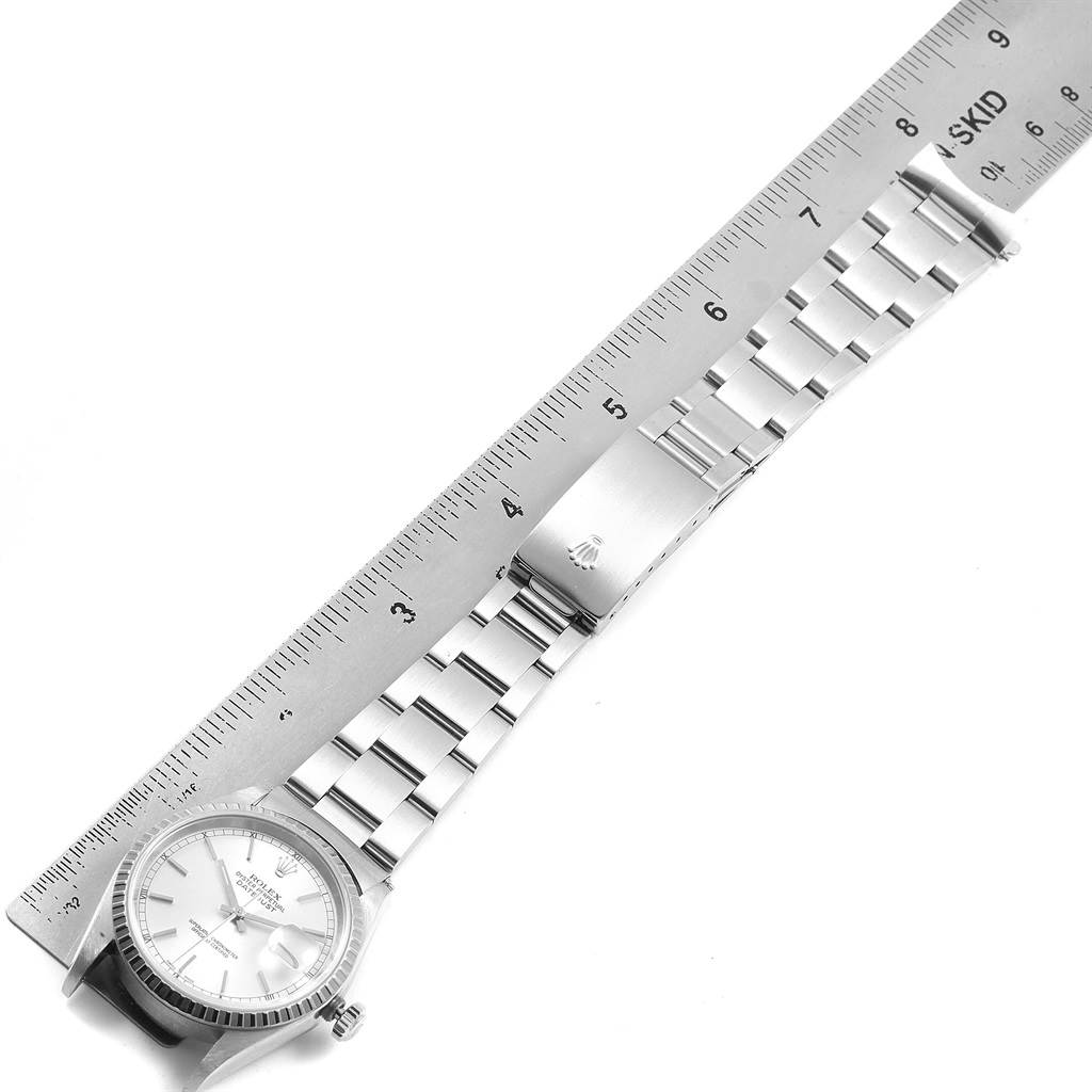 The image shows a top-down view of the Rolex Datejust 16220 Men's Stainless Steel Silver Dial 16220 Men's Stainless Steel Silver Dial watch with its face, bracelet, and clasp fully visible, alongside a ruler.