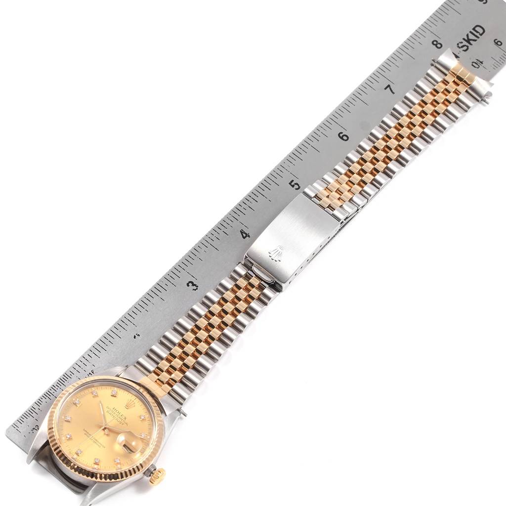 The image shows a Rolex Datejust 16013 Men's Stainless Steel Champagne Dial 16013 Men's Stainless Steel Champagne Dial watch from a top-down angle, highlighting the face, bezel, crown, and jubilee bracelet with a clasp next to a ruler.