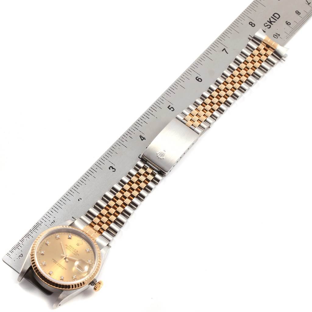 The image shows a Rolex Datejust 16233 Men
s Steel and Gold (two tone) Champagne Dial 16233 Men
s Steel and Gold (two tone) Champagne Dial watch with a Jubilee bracelet laid next to a measuring ruler.