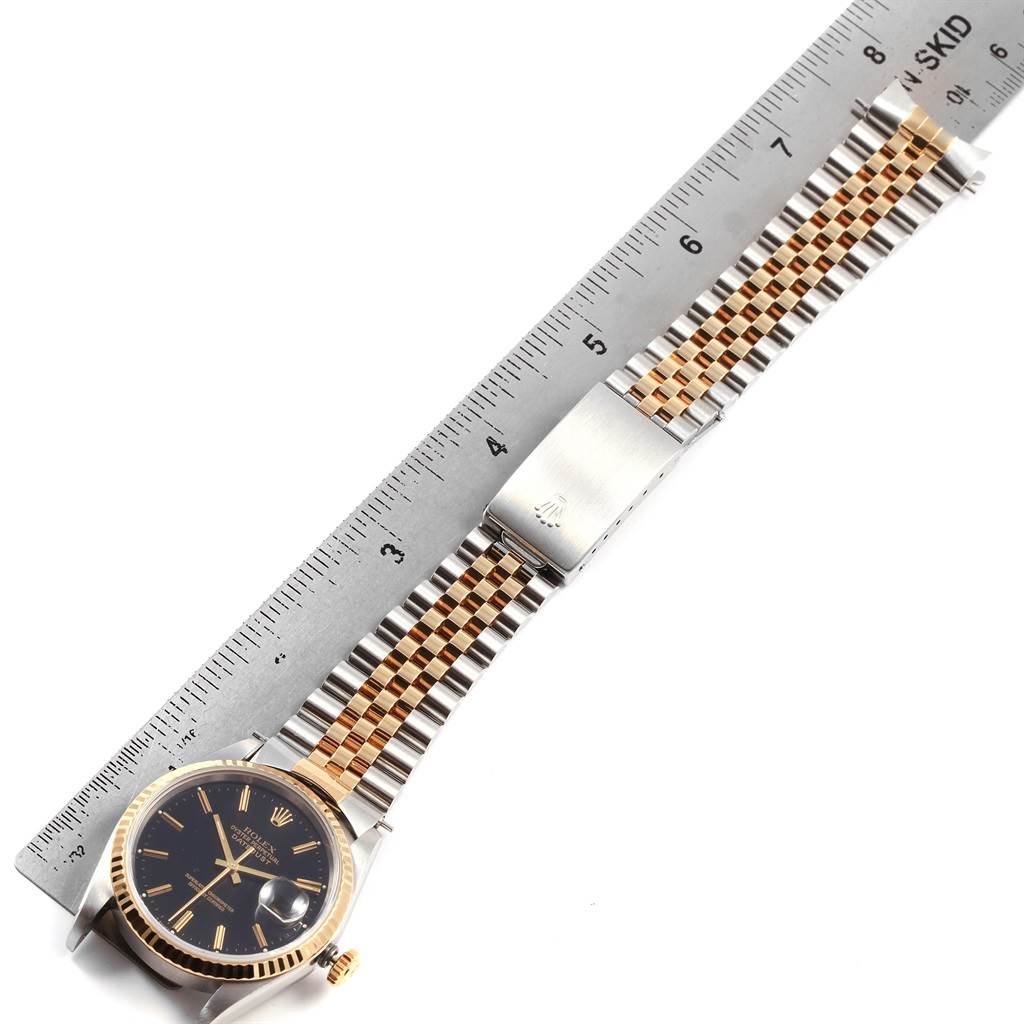 The image shows a Rolex Datejust 16233 Men's Steel and Gold (two tone) Black Dial 16233 Men's Steel and Gold (two tone) Black Dial watch lying flat with a metal ruler next to its bracelet for measurement.