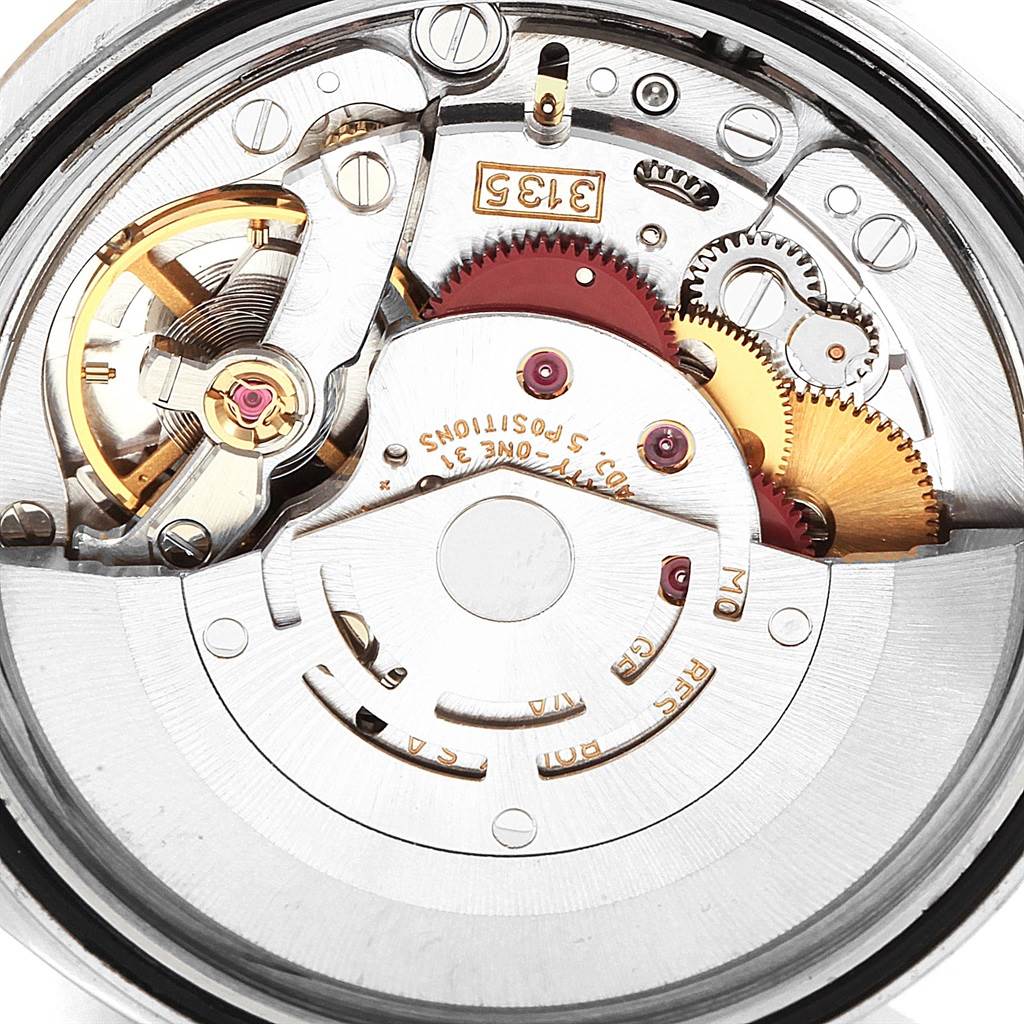 The image shows the intricate inner movement mechanism of a Rolex Datejust 16233 Men's Steel and Gold (two tone) Black Dial 16233 Men's Steel and Gold (two tone) Black Dial watch, featuring gears and components at a close-up angle.