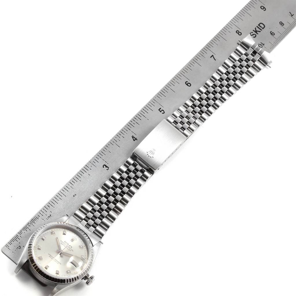 The Rolex Datejust 16234 Men's Stainless Steel Silver Dial 16234 Men's Stainless Steel Silver Dial watch is shown in a top-down angle, highlighting the dial, bracelet, and clasp with a ruler for scale.