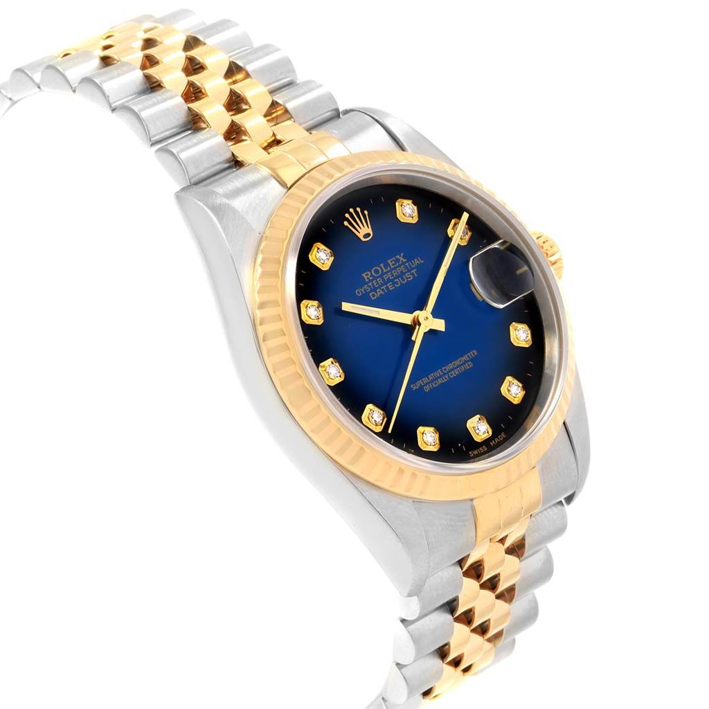 The Rolex Datejust 16233 Men
s Steel and Gold (two tone) Blue Dial 16233 Men
s Steel and Gold (two tone) Blue Dial is shown at a side angle, highlighting the two-tone bracelet, blue dial with diamond hour markers, and fluted bezel.