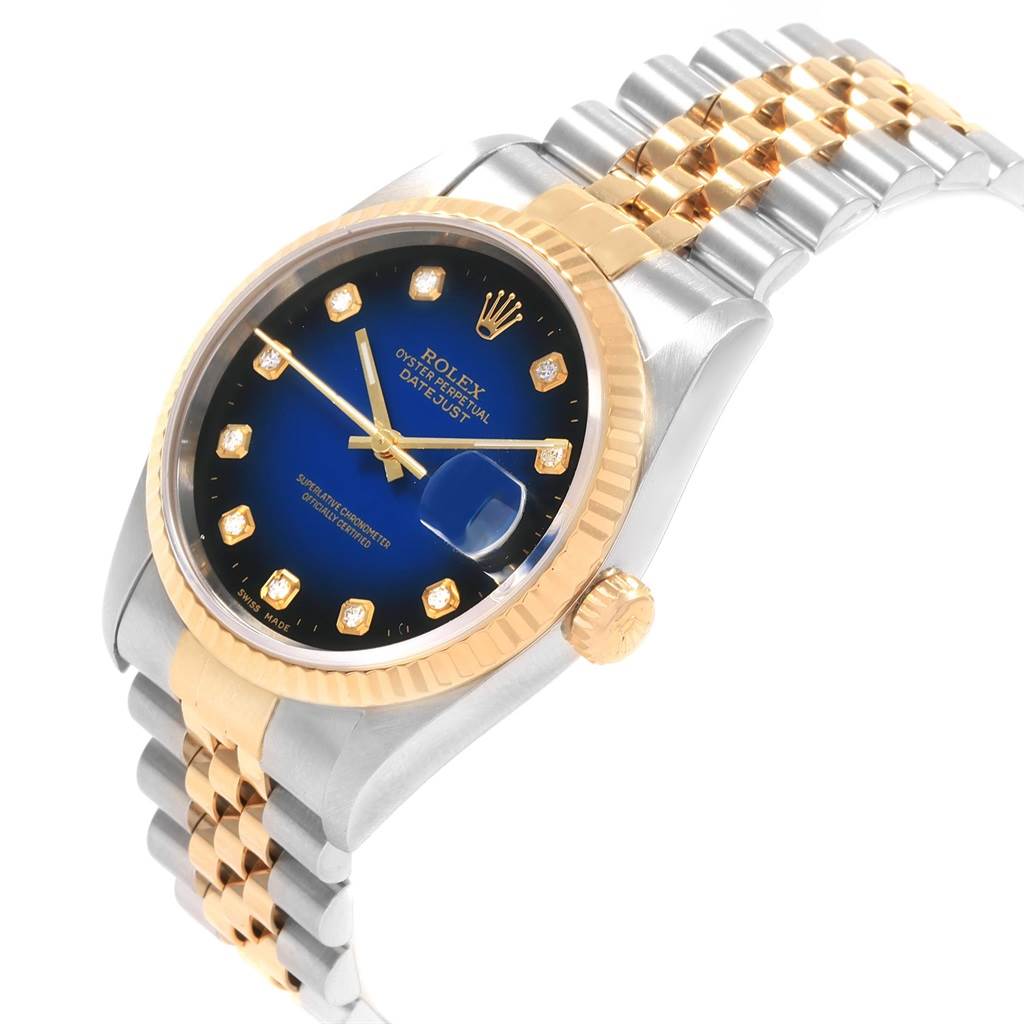 This image shows a Rolex Datejust 16233 Men
s Steel and Gold (two tone) Blue Dial 16233 Men
s Steel and Gold (two tone) Blue Dial watch at an angle highlighting its blue dial, gold fluted bezel, and two-tone Jubilee bracelet.