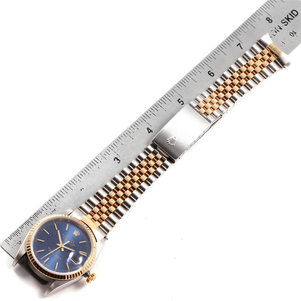 The image shows the face and bracelet of a Rolex Datejust 16233 Men's Steel and Gold (two tone) Blue Dial 16233 Men's Steel and Gold (two tone) Blue Dial watch, viewed from above, alongside a ruler for scale.