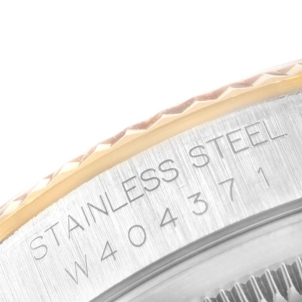 This image shows the side view of the bezel and case, clearly displaying the serial number and "STAINLESS STEEL" engraving on a Rolex Datejust 16233 Men's Steel and Gold (two tone) Champagne Dial 16233 Men's Steel and Gold (two tone) Champagne Dial.