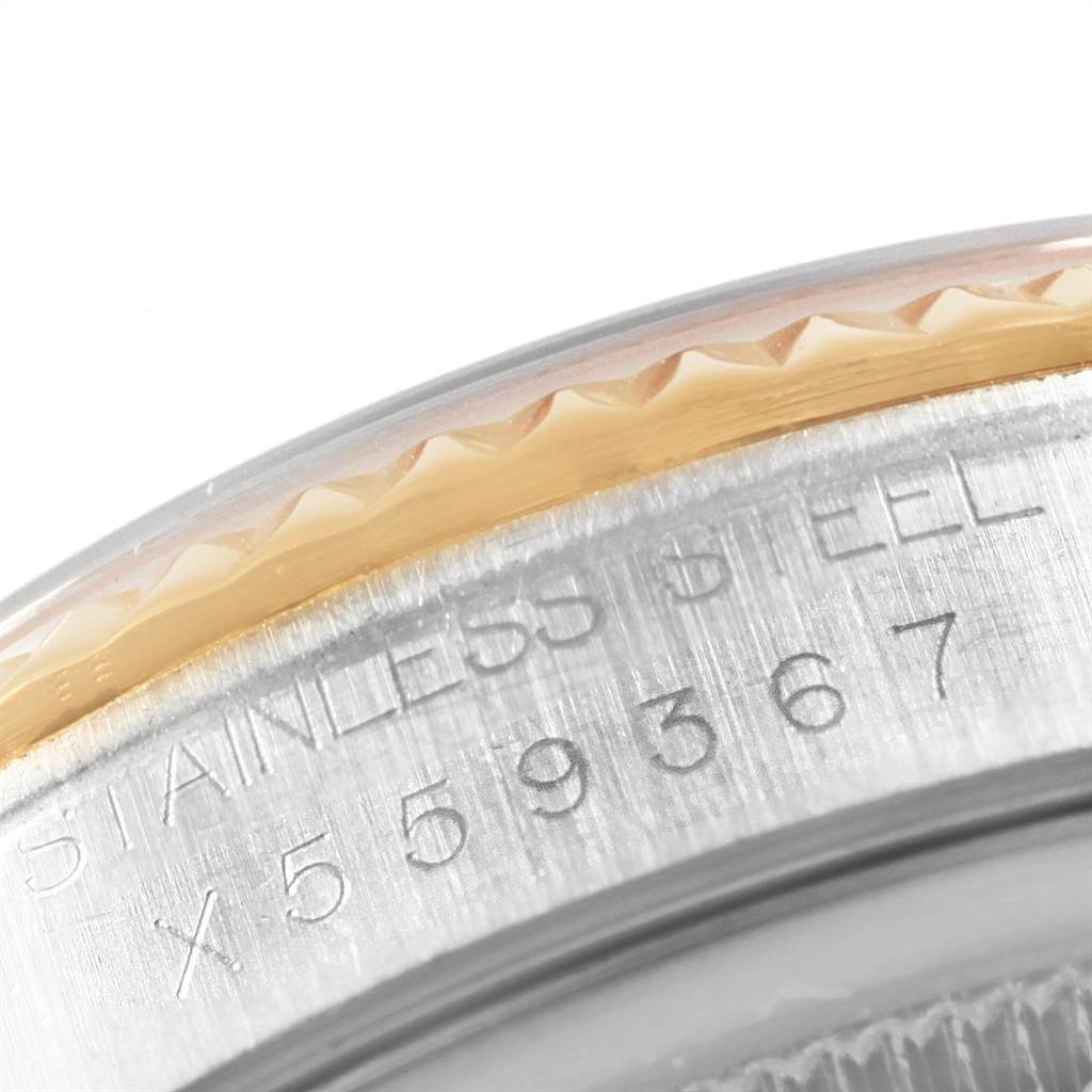 This close-up image shows the engraved serial number and the fluted bezel detail of a Rolex Datejust 16233 Men's Steel and Gold (two tone) White Dial 16233 Men's Steel and Gold (two tone) White Dial watch.