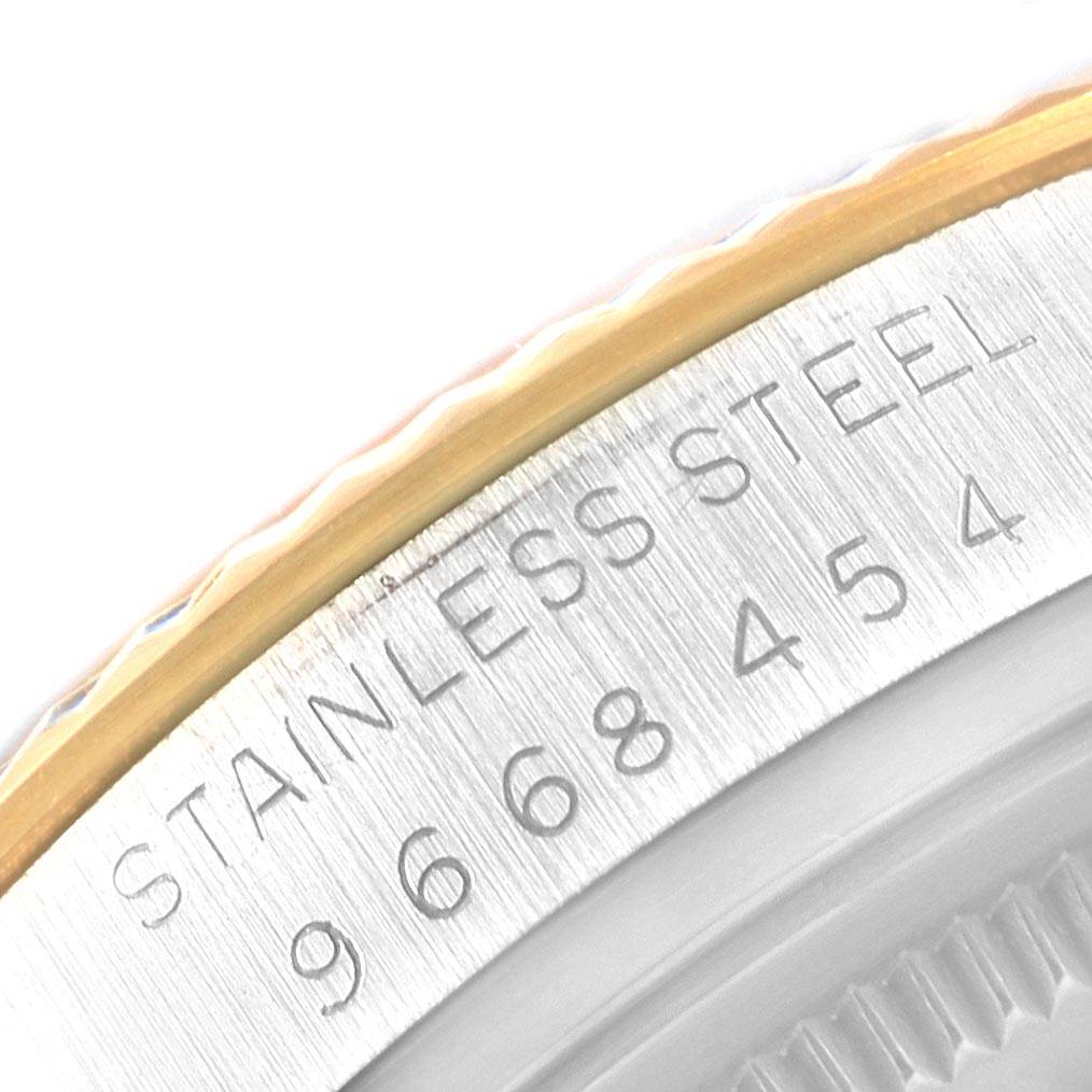 This close-up image of a Rolex Datejust 16013 Men's Stainless Steel Silver Dial 16013 Men's Stainless Steel Silver Dial watch shows part of the bezel and case with "STAINLESS STEEL" and a serial number engraved.