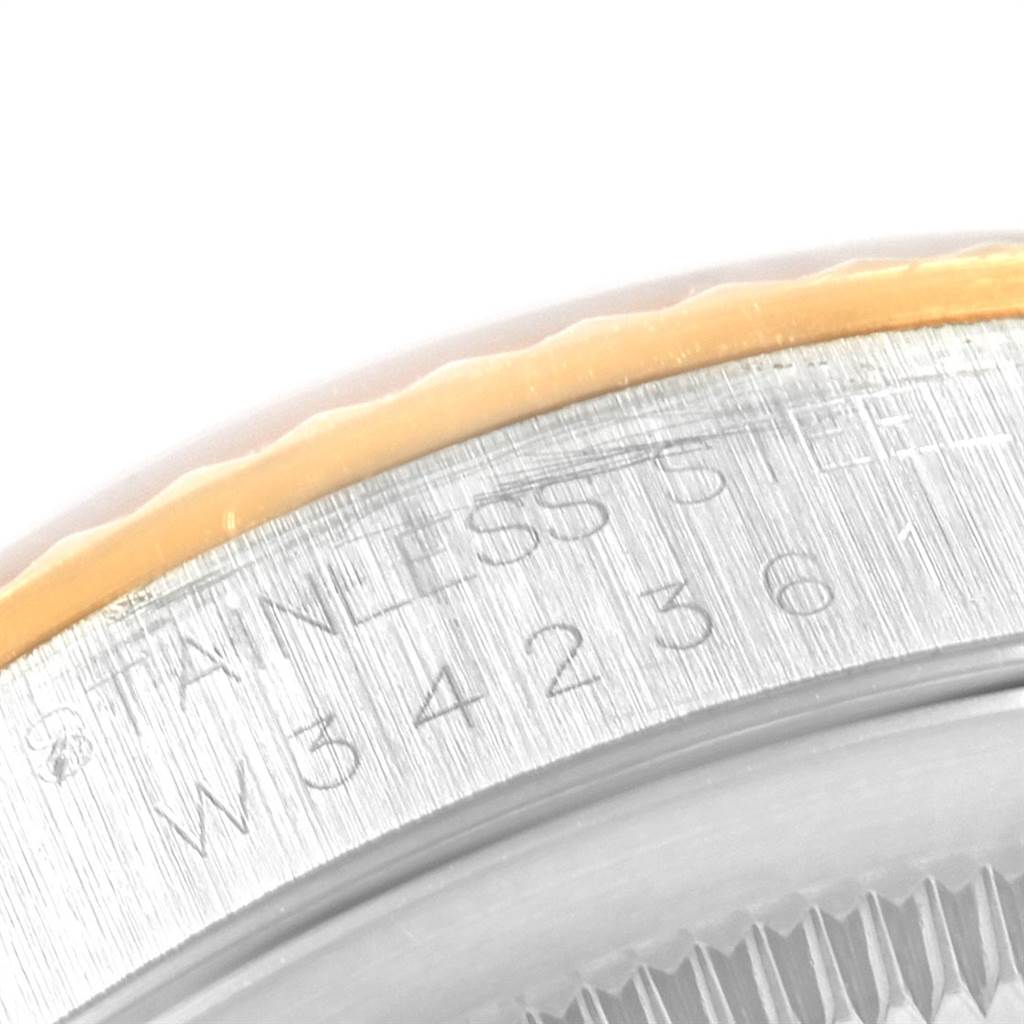 The close-up image shows the side view of the bezel and case of the Rolex Datejust 16233 Men's Steel and Gold (two tone) Champagne Dial 16233 Men's Steel and Gold (two tone) Champagne Dial model, displaying part of its serial number and "Stainless Steel" engraving.