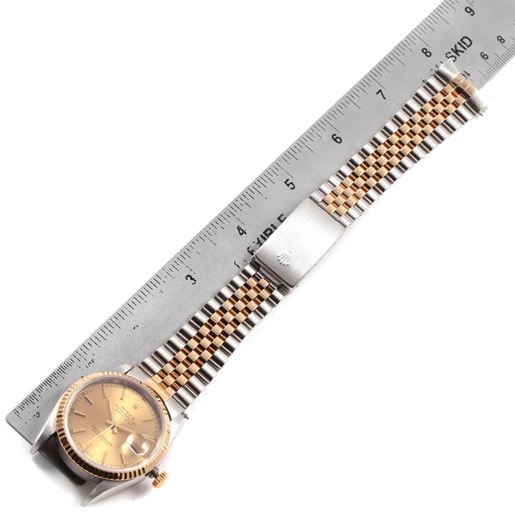 This image shows a Rolex Datejust 16233 Men's Steel and Gold (two tone) Champagne Dial 16233 Men's Steel and Gold (two tone) Champagne Dial watch laid flat with a focus on the bezel, dial, and the entire bracelet alongside a ruler for scale.