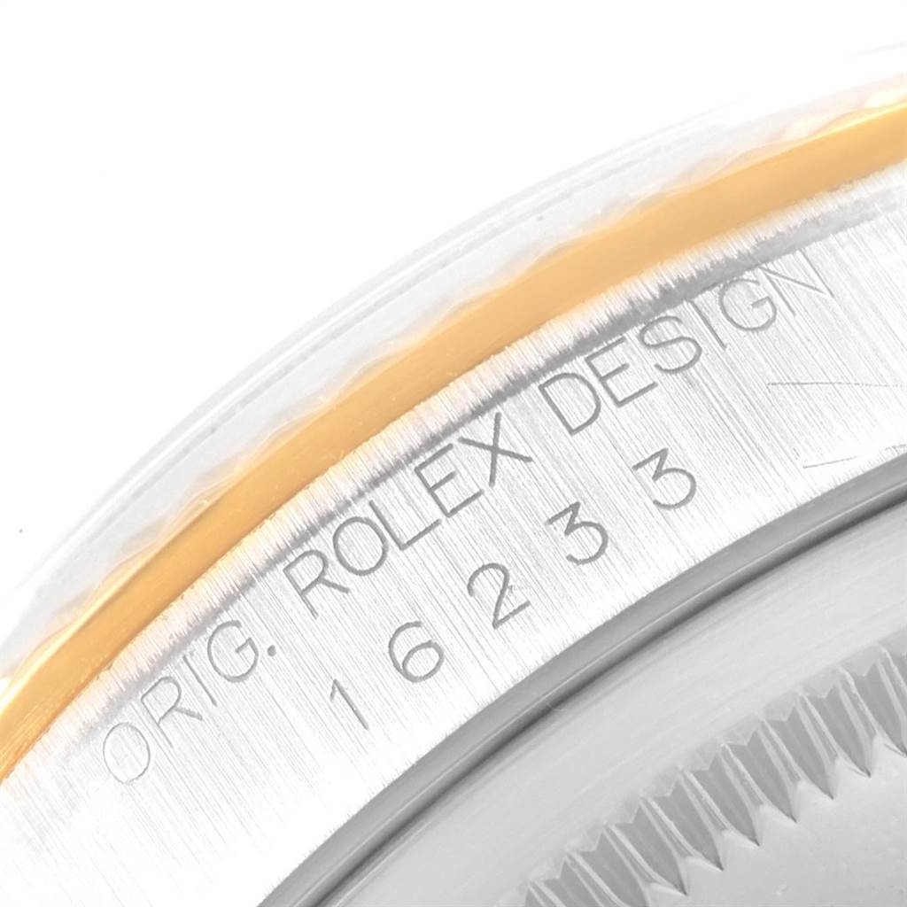 The image shows a close-up of the Rolex Datejust 16233 Men's Steel and Gold (two tone) Blue Dial 16233 Men's Steel and Gold (two tone) Blue Dial watch's case side, highlighting the "ORIG. ROLEX DESIGN" engraving and model number.