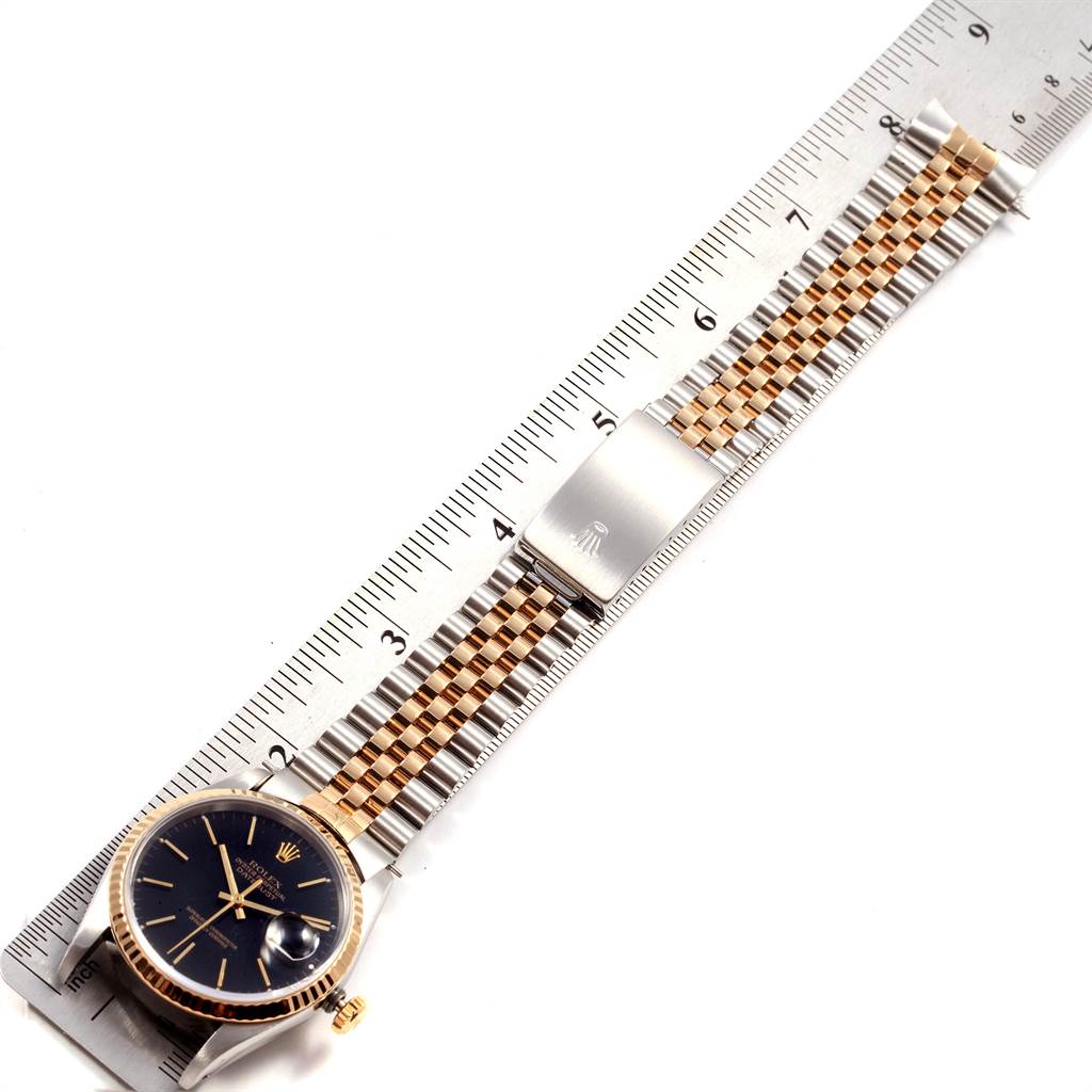 The image shows a Rolex Datejust 16233 Men's Steel and Gold (two tone) Black Dial 16233 Men's Steel and Gold (two tone) Black Dial watch placed alongside a ruler, displaying the dial and the entire bracelet.