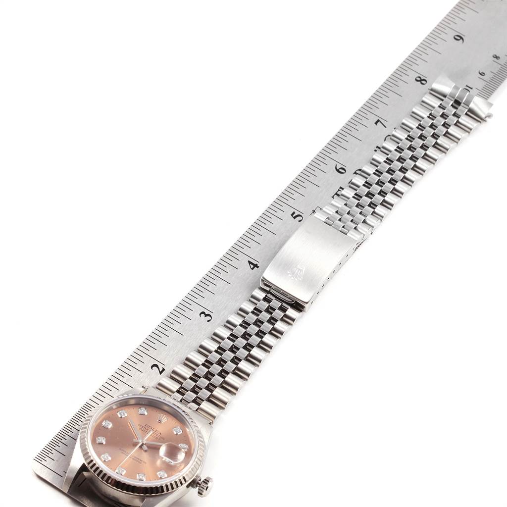 The Rolex Datejust 16234 Men
s Stainless Steel Pink Dial 16234 Men
s Stainless Steel Pink Dial watch is shown lying flat with its bracelet extended next to a ruler for measurement.