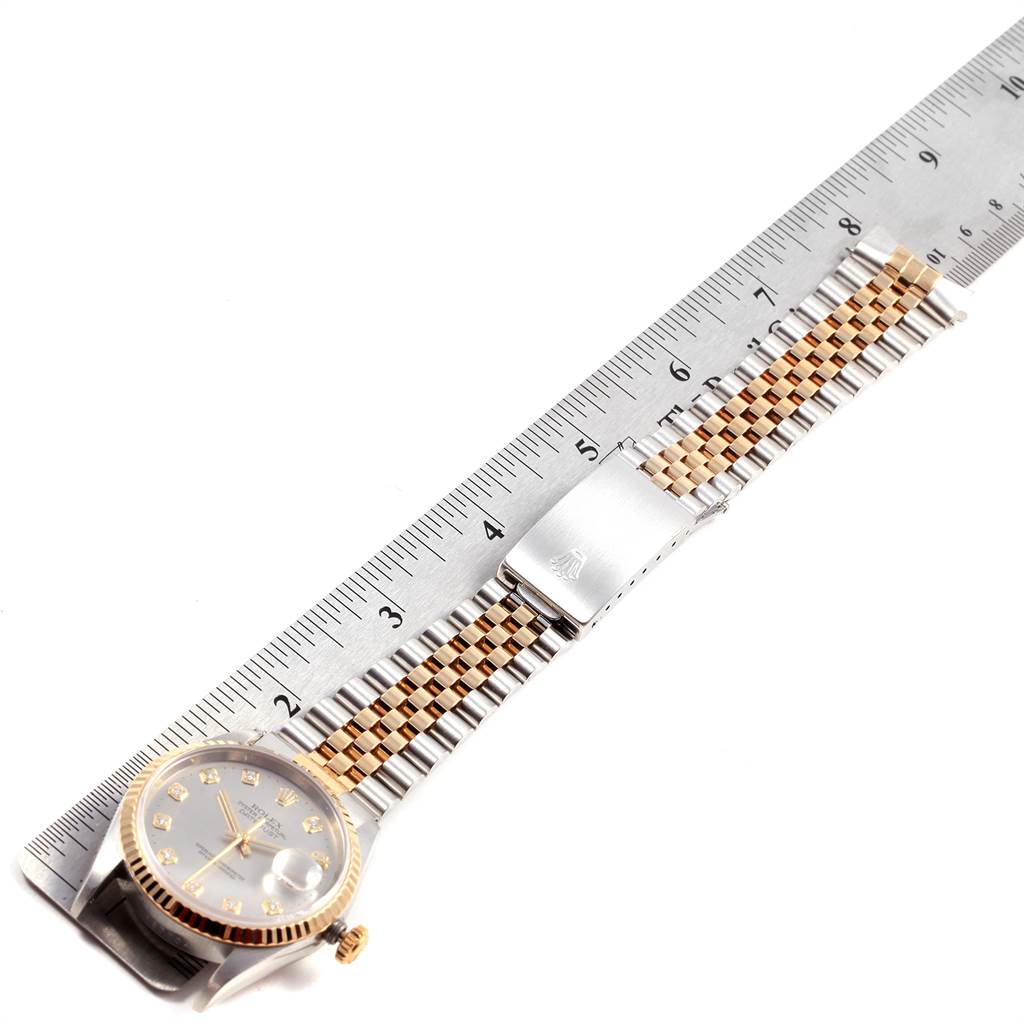 The image shows a Rolex Datejust 16233 Men
s Steel and Gold (two tone) Silver Dial 16233 Men
s Steel and Gold (two tone) Silver Dial watch laid flat, with a focus on the band measured against a ruler.