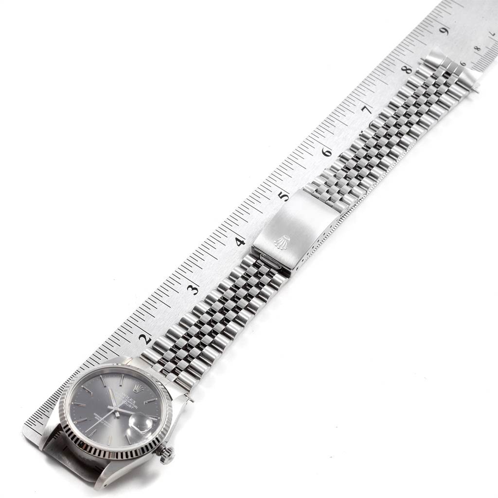 The image shows a top view of a Rolex Datejust 16234 Men's Stainless Steel Grey Dial 16234 Men's Stainless Steel Grey Dial watch with its entire bracelet laid flat next to a ruler.