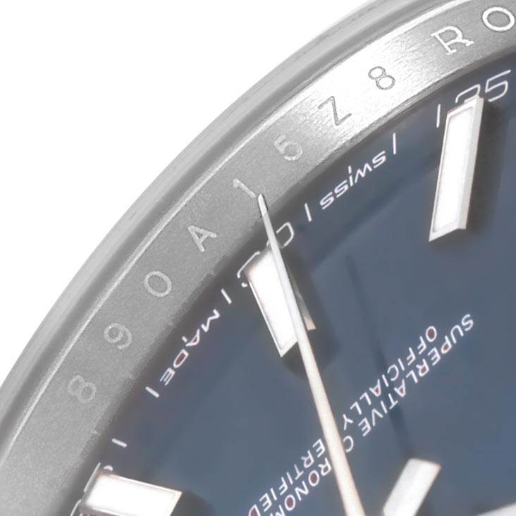 The image shows a close-up of the dial and bezel of a Rolex Datejust 126300 Men
s Stainless Steel Blue Dial 126300 Men
s Stainless Steel Blue Dial watch, highlighting the hour markers and inscriptions.