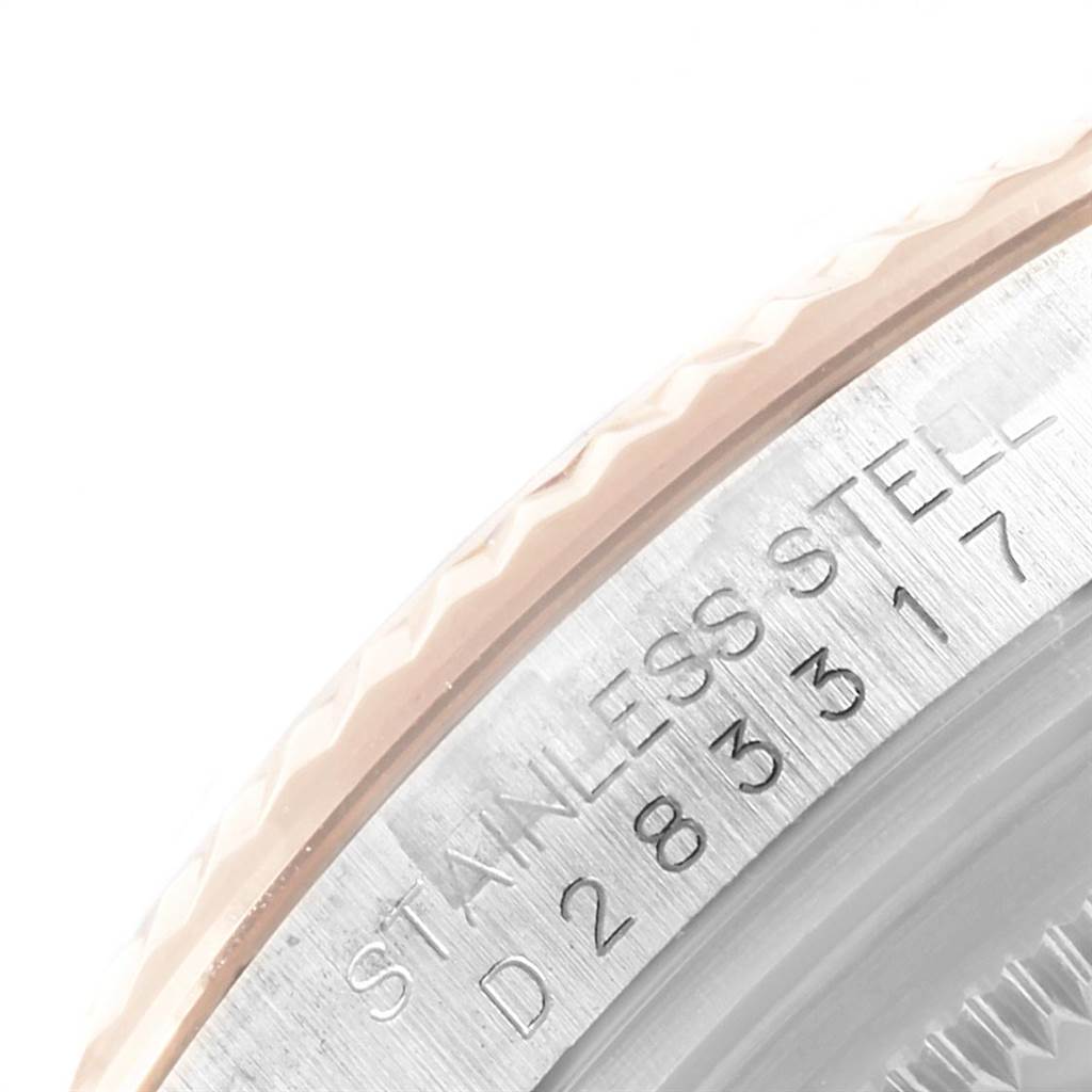 This image shows a close-up of the engraved serial number and fluted bezel on a Rolex Datejust 116231 Men's Steel and Gold (two tone) Black Dial 116231 Men's Steel and Gold (two tone) Black Dial model watch.