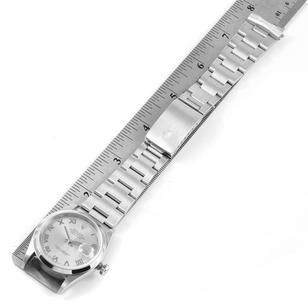 This image shows a Rolex Datejust 16200 Men's Stainless Steel Grey Dial 16200 Men's Stainless Steel Grey Dial model watch from a top-down view alongside a ruler, highlighting the dial and bracelet.