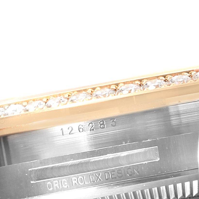 Close-up view of the Rolex Datejust 126283 Men's Steel and Gold (two tone) Green Dial 126283 Men's Steel and Gold (two tone) Green Dial model showing the bezel with diamonds and part of the case with engravings.