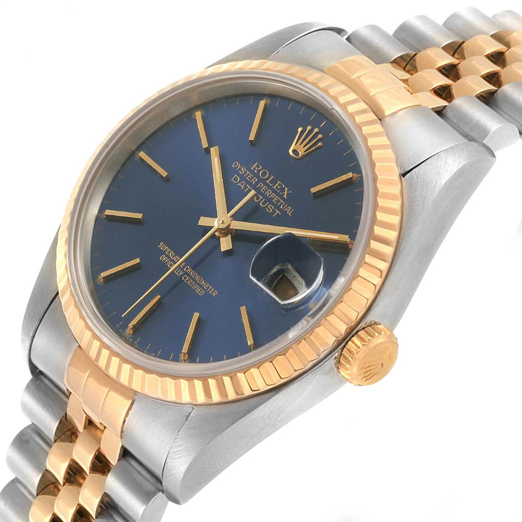 The Rolex Datejust 16233 Men
s Steel and Gold (two tone) Blue Dial 16233 Men
s Steel and Gold (two tone) Blue Dial watch is shown at a slight angle, highlighting the blue dial, fluted bezel, and two-tone bracelet.