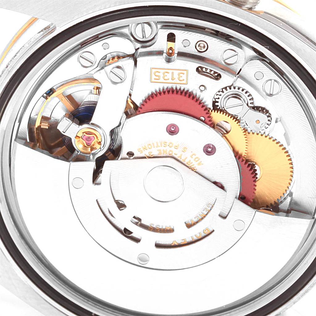 The image shows the internal mechanical movement of a Rolex Datejust 116243 Men's Stainless Steel Black Dial 116243 Men's Stainless Steel Black Dial watch from a rear angle, highlighting gears and components.