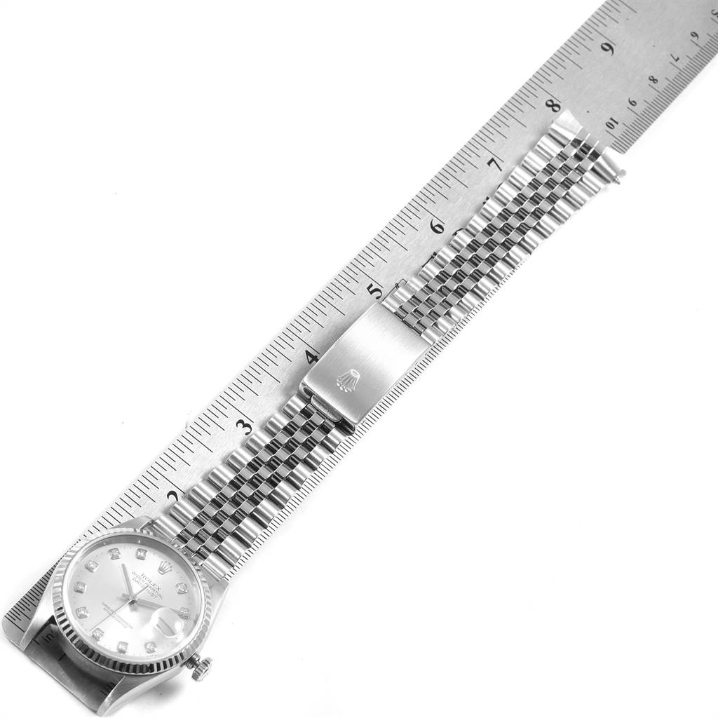 The image shows a Rolex Datejust 16234 Men's Stainless Steel Silver Dial 16234 Men's Stainless Steel Silver Dial watch laid flat next to a ruler, displaying its face, bracelet, and clasp.